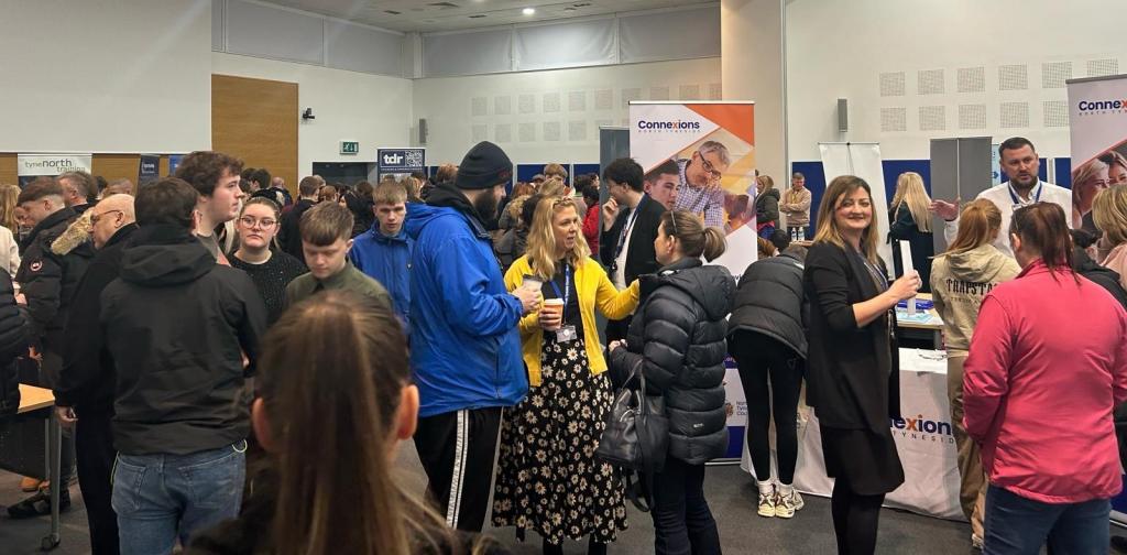 A large number of people talking to eachother at an apprenticeship fair