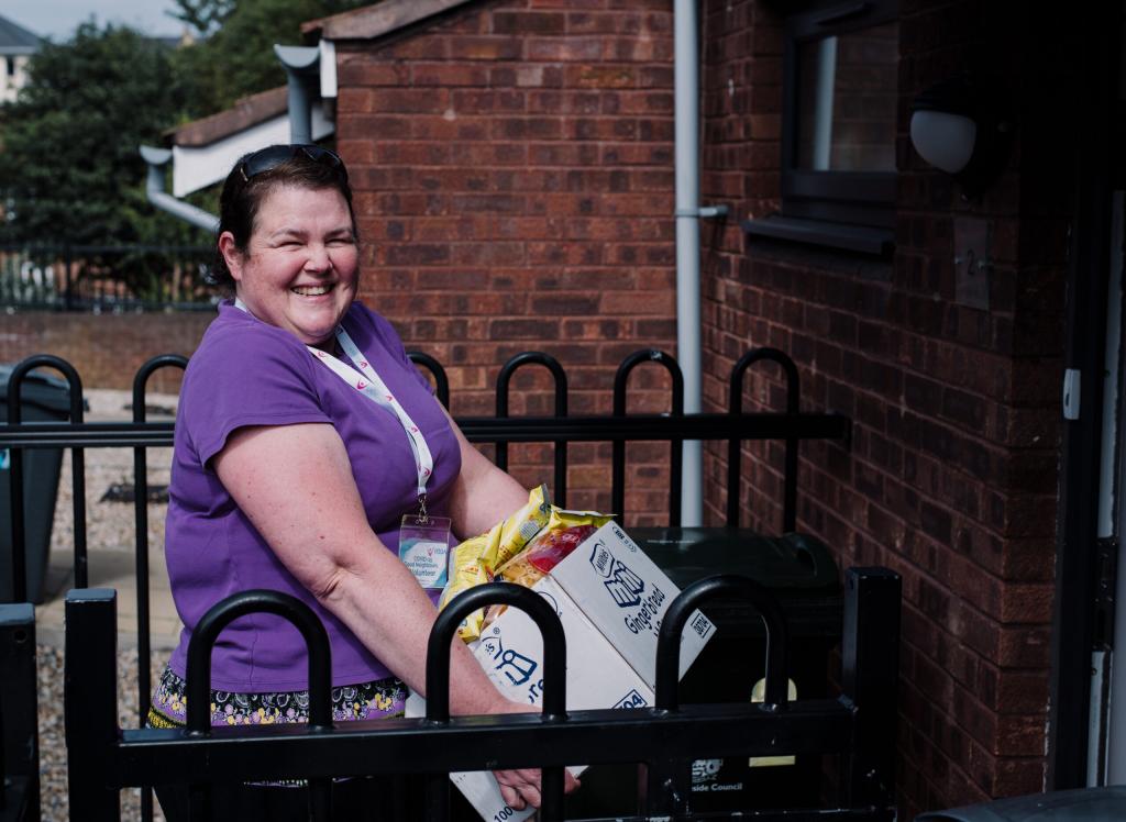 A volunteer from VODA delivers a food parcel