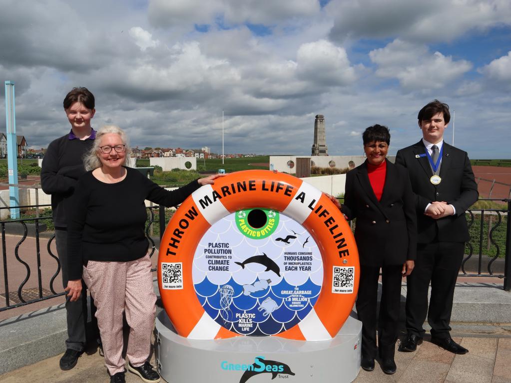 People stood in front of recycling bin