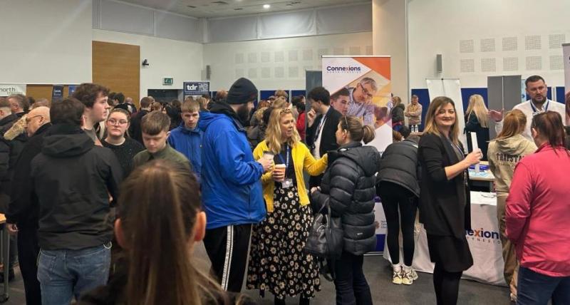 A large number of people talking to eachother at an apprenticeship fair