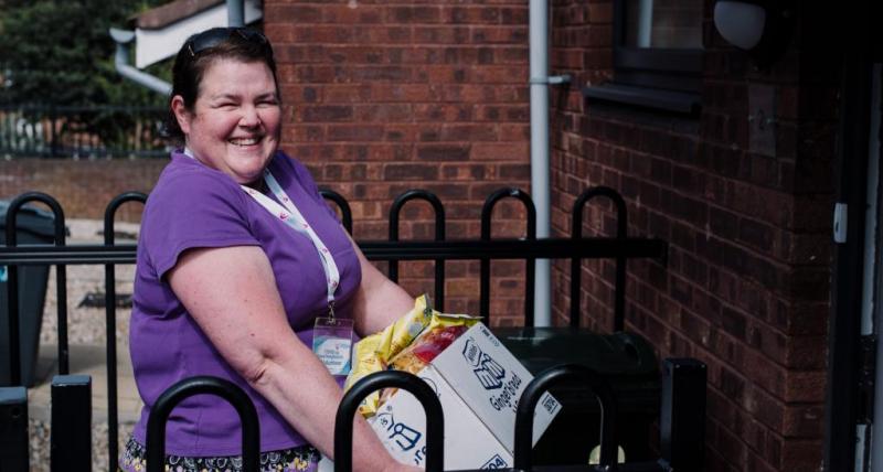 A volunteer from VODA delivers a food parcel