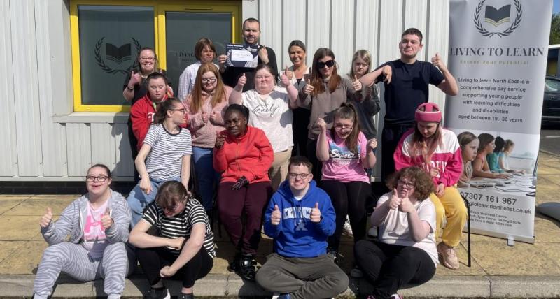 Staff and service users from Living to Learn celebrate their Silver Carbon Reduction Award