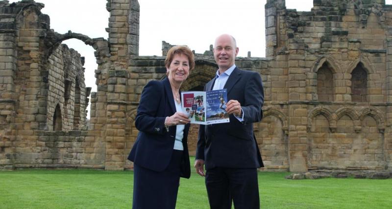 North Tyneside Elected Mayor, Norma Redfearn and Port of Tyne’s Paul Moffat holding a festival programme inside Tynemouth Priory and Castle.